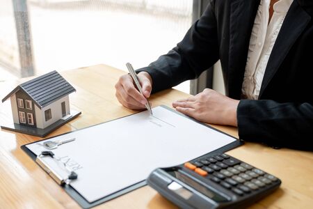 agents working in real estate investment and home insurance signing contracts in accordance with home buying insurance agreements approving purchases for clients.の写真素材