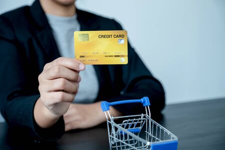 Office girl who holds a credit card for online shopping.の写真素材