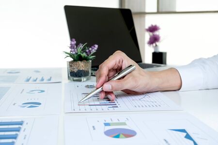 business man is sitting at a desk and calculating financial graph that show results In the office.