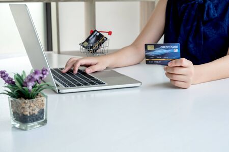 Office women that hold credit cards and use laptops for online shopping online and making payments Internet.の写真素材