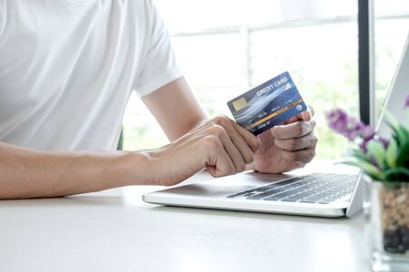 Young man people who hold credit cards and use laptops for online shopping and making payments...