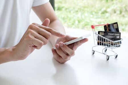 Young man people who hold credit cards and smartphones for online shopping and making payments...
