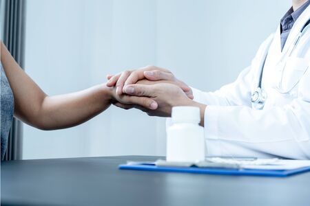 Male doctors use friendly hands to hold the patient's confidence and recommend health care. Medical concepts and good health.の写真素材