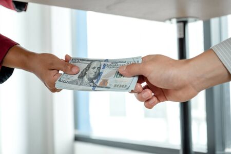 Photos of businessmen who give money under the table to a partner to bribe the idea of...