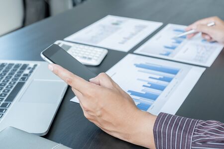 The hands of a male businessman are analyzing and calculating the annual income and expenses in a...