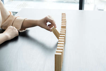 Hands of businesswomen playing wooden block game. Concept Risk of management and strategy plans for business growth and success.の写真素材