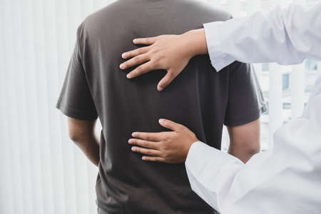 Male patients consulted physiotherapists with Low back pain for examination and treatment. Rehabilitation physiotherapy concept.の写真素材