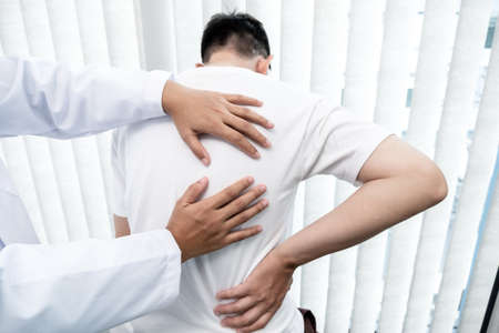 Male patients consulted physiotherapists with Low back pain for examination and treatment. Rehabilitation physiotherapy concept.の写真素材