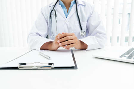The female doctor sat and checked the patient's history and used a laptop to record patient information at the hospital. Medical concepts and interests.の写真素材