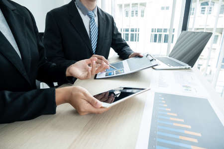 Two business leaders talk about charts, financial graphs showing results are analyzing and calculating planning strategies, business success building processes.の写真素材