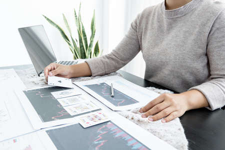 The girl's hand is a stockbroker who holds cards and plans a business investment by analyzing and...