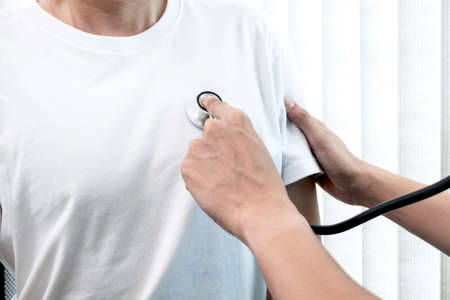 Male doctors perform a pulse examination using a stethoscope. Initial health check-up at the hospital Concepts of treatment and good health.の写真素材