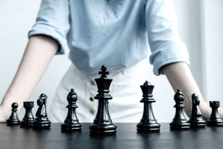 The hands of businesswomen moving chess in chess competitions demonstrate leadership, followers, and strategic plans, business success building processes, and teamwork.の写真素材