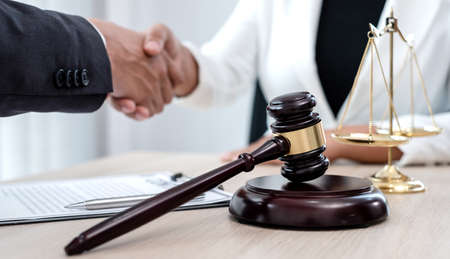 shake hand Professional male lawyers work at a law office There are scales, Scales of justice, judges gavel, and litigation documents. Concepts of law and justice.の写真素材