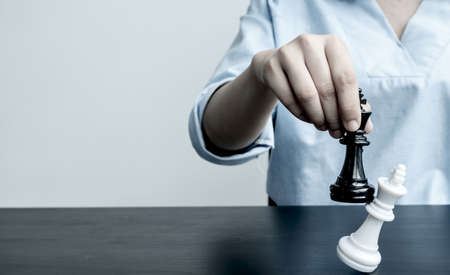 The hands of businesswomen moving chess in chess competitions demonstrate leadership, followers, and strategic plans, business success building processes, and teamwork.の写真素材