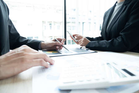 Two business leaders talk about charts, financial graphs showing results are analyzing and calculating planning strategies, business success building processes.の写真素材