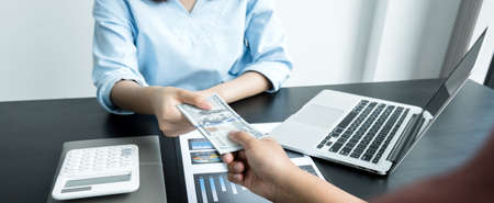 A photo of a businessman who gives money to his partner to bribe the idea of ââbribery and corruption.の写真素材