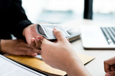 The businesswoman offers and gives money to his partners for bribery of bribery and corruption.の写真素材