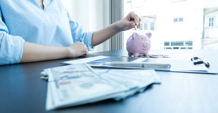 Women's hands are putting coins in the piggy bank Saving money with coins Step into a business that...