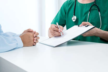 Male doctors explain and recommend treatment after a female patient meets a doctor and receives results regarding illness problems. Medical and health care concepts.の写真素材