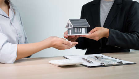 Real estate agent broker hand over the home to the new owner after completing the signing according...