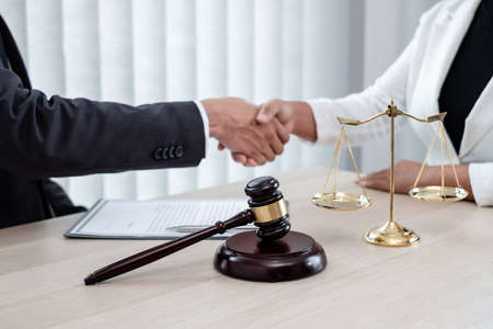 shake hand Professional male lawyers work at a law office There are scales, Scales of justice, judges gavel, and litigation documents. Concepts of law and justice.の写真素材
