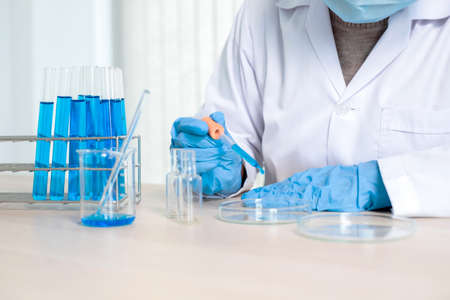 Medical scientists released a sample pipetted into test glassware to analyze the virus in a chemical laboratory. Scientific research concepts.の写真素材