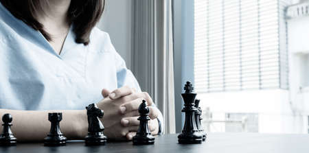 The hands of businesswomen moving chess in chess competitions demonstrate leadership, followers, and strategic plans, business success building processes, and teamwork.の写真素材