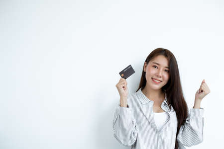 The hand of an Asian woman holding a credit card is used for online shopping and Internet payments.の写真素材