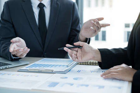 Two business leaders talk about charts, financial graphs showing results are analyzing and...