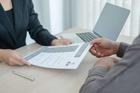 Business people hold a resume and talk to job applicants for job interviews about careers and Her...