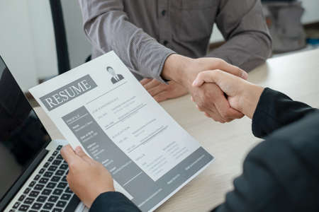 Friendly businessmen and executives shake hands after successful agreement with employment...