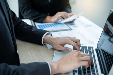 Two business leaders talk about charts, financial graphs showing results are analyzing and...