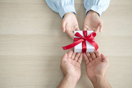 Gift box hand holding a gift box Glad to be the giver of surprise with excitement, the joy on the holidays, Christmas, birthdays, or Valentine's Day concept.の写真素材
