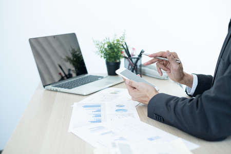 The businessman hand sits at their desks and calculates financial graphs showing the results of their investments planning the process of successful business growth.の写真素材