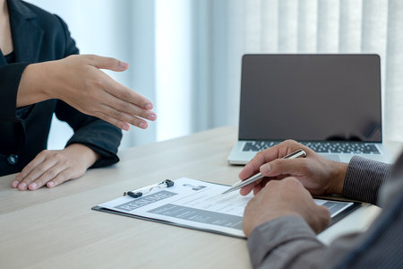 Business people hold a resume and talk to job applicants for job interviews about careers and Her...