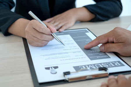 Business people hold a resume and talk to job applicants for job interviews about careers and Her...