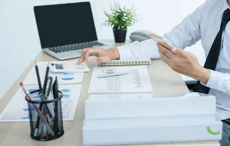 The businessman hand sits at their desks and calculates financial graphs showing the results of their investments planning the process of successful business growth.の写真素材