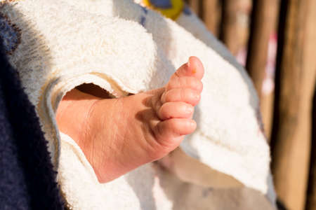 Tiny newborn baby feet, tiny newborn bare feet in parental hands. Happy family concept.