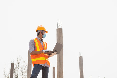 The construction site male engineer or architect is exploring and inspecting the outdoor...