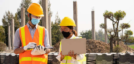 A team of male and female engineers or architects is exploring and inspecting the outdoor construction site work.の写真素材