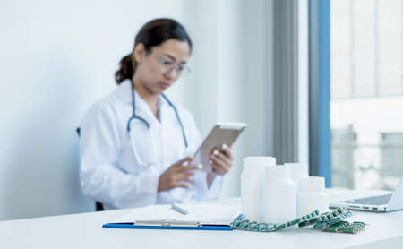 Medicine tablets, a female doctor In uniform Asians sit in the hospital.の写真素材