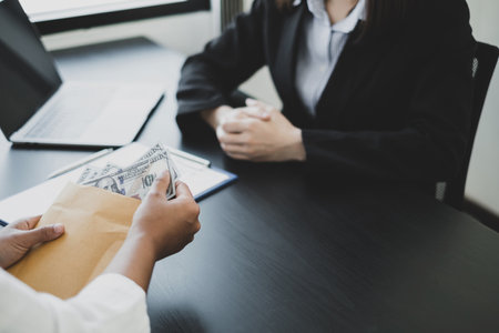 Businessmen make an agreement with the money proposed his partner to bribe in the company. The concept of bribery and corruption.の写真素材