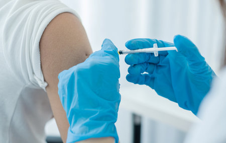 Female doctors vaccinated with syringes to prevent epidemics at hospitals, health care, and medical...
