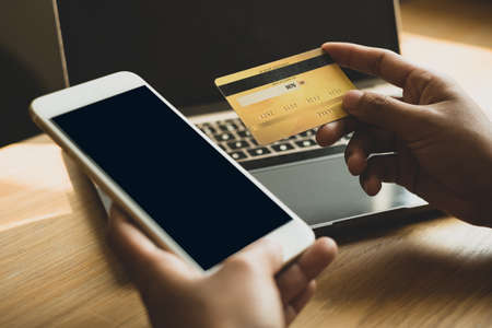 The businesswoman's hand is holding a credit card and using a smartphone for online shopping and internet payment.の写真素材