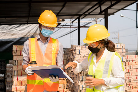 A team of male and female engineers or architects is exploring and inspecting the outdoor...