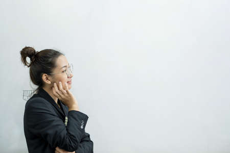 An Asian female teacher in a classroom near the whiteboard is writing and teaching a lesson with a special lecture in a class column. Math teacher explains arithmetic sums to university students.の写真素材