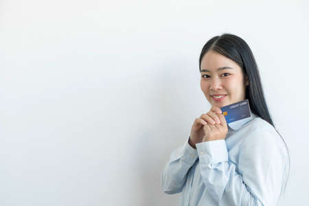 The hand of an Asian woman holding a credit card is used for online shopping and Internet payments.