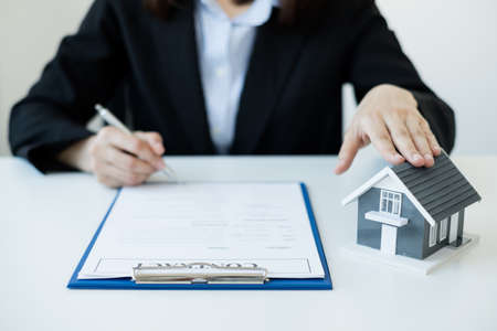 agents working in real estate investment and home insurance signing contracts in accordance with the home buying insurance agreements approving purchases for clients.の写真素材
