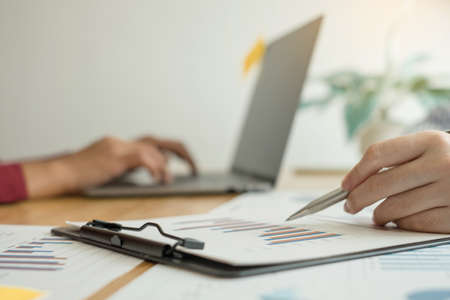 Two business leaders talk about charts, financial graphs showing results are analyzing and calculating planning strategies, business success building processes.の写真素材